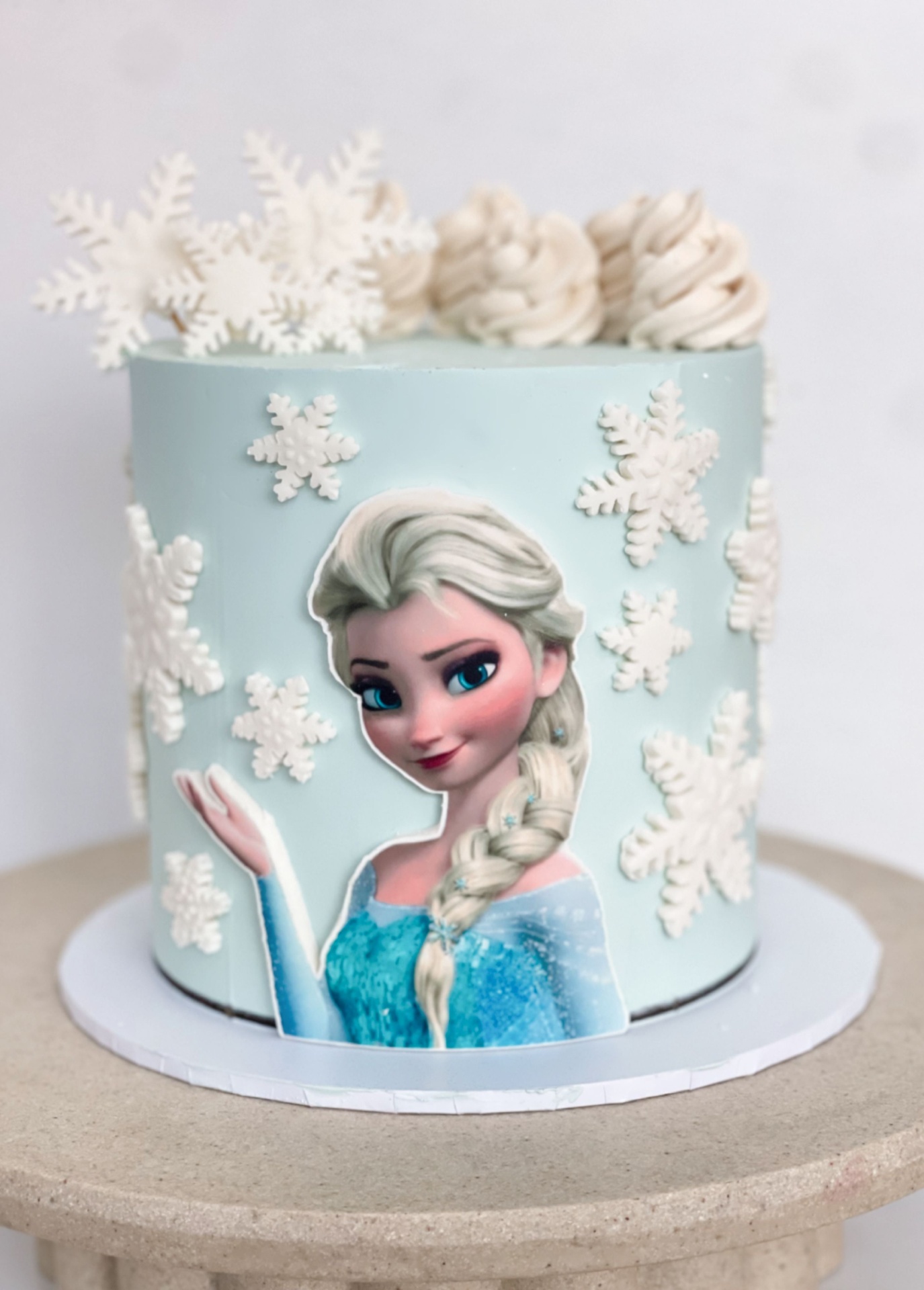 Pale blue Frozen Elsa cake with snowflake decorations